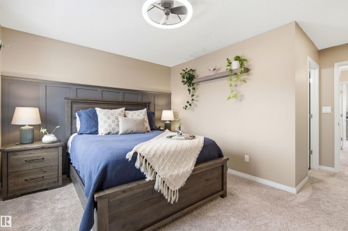 Bedroom featuring plush carpet flooring, a decorative wall panel accent, and a modern ceiling fan with integrated lighting - 3247 Cherry Crescent, Edmonton, AB - Indoor Photo Showing Bedroom