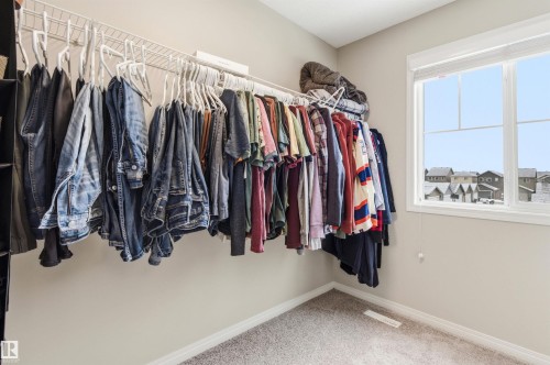 This property features a room with light-colored walls and carpeted flooring, complete with a window offering views of the surrounding neighborhood - 3247 Cherry Crescent, Edmonton, AB - Indoor With Storage