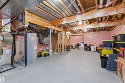 The property includes an unfinished basement with exposed wooden beams, insulation, and a water heater - 3247 Cherry Crescent, Edmonton, AB - Indoor Photo Showing Basement
