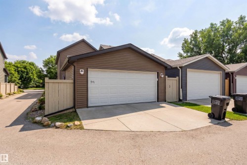 The property features a garage with a white door and brown siding - 3247 Cherry Crescent, Edmonton, AB - Outdoor With Exterior