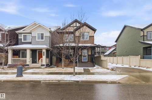 This property features a two-story exterior with a covered front porch, dark siding, and light-colored trim - 3247 Cherry Crescent, Edmonton, AB - Outdoor With Facade