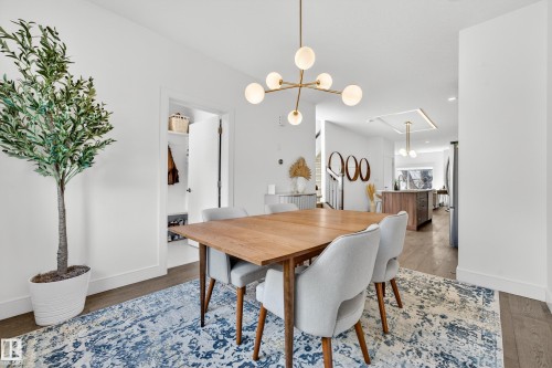 The dining area features hardwood flooring, a modern light fixture, and an open doorway leading to a closet - 7624 91 Avenue, Edmonton, AB - Indoor Photo Showing Dining Room