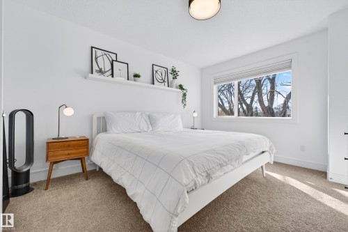 This room features a window with an outdoor view, carpeted flooring, and a white ceiling with a light fixture - 7624 91 Avenue, Edmonton, AB - Indoor Photo Showing Bedroom