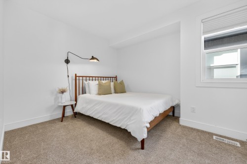 The room features neutral-toned carpet, white walls, and a window with blinds - 7624 91 Avenue, Edmonton, AB - Indoor Photo Showing Bedroom