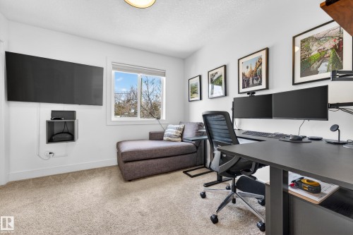 This versatile room features light-colored carpeting, a window providing natural light, and a dedicated workspace - 7624 91 Avenue, Edmonton, AB - Indoor Photo Showing Office