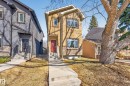 The property features a two-story exterior with a red front door, stone accents, and several windows - 7624 91 Avenue, Edmonton, AB  - Outdoor With Facade 