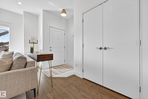 Entryway featuring hardwood flooring, a white front door, and white paneled closet doors - 7624 91 Avenue, Edmonton, AB - Indoor Photo Showing Other Room