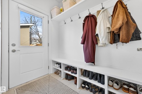 Mudroom featuring a white door with a window, wall-mounted coat hooks, and built-in shelving for storage - 7624 91 Avenue, Edmonton, AB - Indoor Photo Showing Other Room
