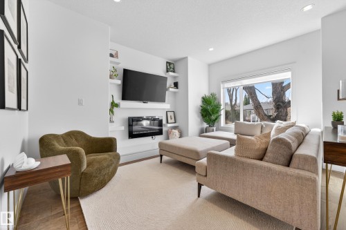 The living area features bright walls, recessed lighting, and a large window providing natural light - 7624 91 Avenue, Edmonton, AB - Indoor Photo Showing Living Room With Fireplace