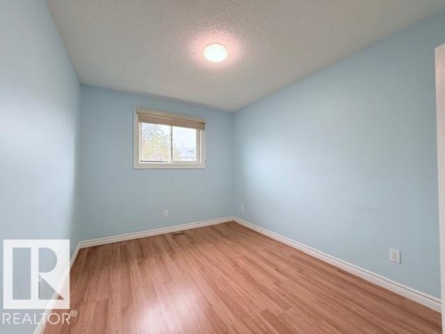 This room features light blue walls, wood flooring, and a window with blinds providing natural light - 2831 36 Street, Edmonton, AB - Indoor Photo Showing Other Room