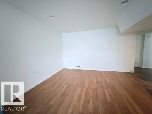 This room features light-toned hardwood flooring and recessed lighting, offering a clean and bright aesthetic - 2831 36 Street, Edmonton, AB - Indoor Photo Showing Other Room