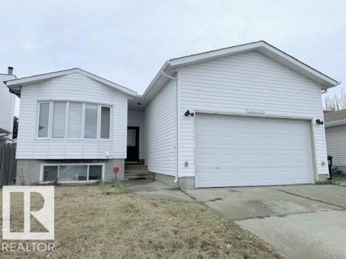 The property features white siding, a prominent two-car garage, and a concrete driveway - 2831 36 Street, Edmonton, AB - Outdoor