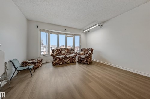 Living area featuring a bay window, light wood-style flooring, and white walls - 2831 36 Street, Edmonton, AB - Indoor Photo Showing Living Room