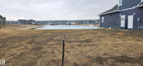 The property features a large yard with views of a lake and surrounding residences - 13 Sunset Harbour, Rural Wetaskiwin County, AB 