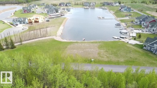 This property features a generous plot of land with verdant foliage and paved road access - 13 Sunset Harbour, Rural Wetaskiwin County, AB 