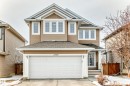 The property features light brown siding, white trim, and a prominent attached garage with a white door - 1330 114B Street, Edmonton, AB  - Outdoor With Facade 
