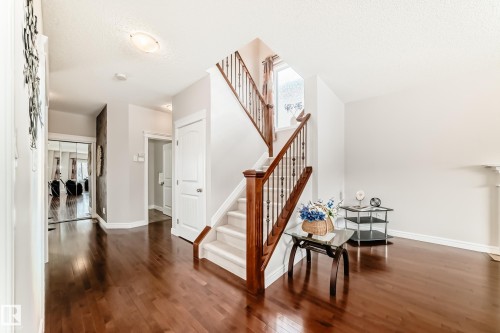 Welcoming foyer featuring rich hardwood floors, a staircase with wood banisters and white risers, and bright, neutral wall finishes - 1330 114B Street, Edmonton, AB - Indoor Photo Showing Other Room