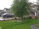 The property features a well-maintained lawn, mature trees, and landscaping around the front of the home - 1330 114B Street, Edmonton, AB  - Outdoor 