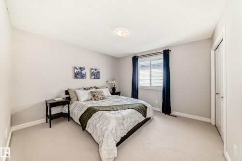 The bedroom features light-colored walls, carpeted flooring, and a window with blinds and dark curtains - 1330 114B Street, Edmonton, AB - Indoor Photo Showing Bedroom
