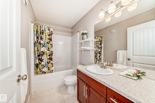 Well-appointed bathroom featuring a vanity with a light-colored countertop and a mirror with overhead lighting - 1330 114B Street, Edmonton, AB - Indoor Photo Showing Bathroom
