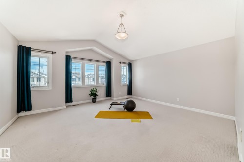 Spacious room featuring vaulted ceilings, light-colored carpeting, and windows with dark curtains - 1330 114B Street, Edmonton, AB - Indoor Photo Showing Other Room