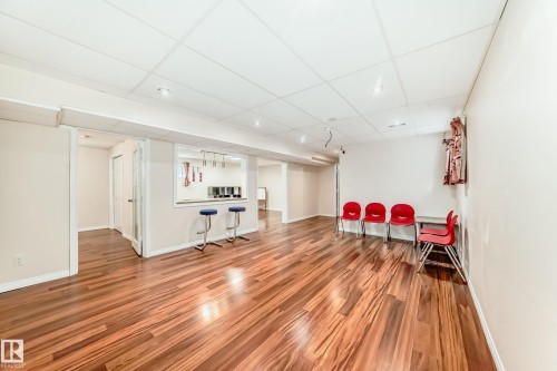 Expansive interior space featuring a warm-toned wooden floor and a drop ceiling with recessed lighting - 1330 114B Street, Edmonton, AB - Indoor Photo Showing Other Room
