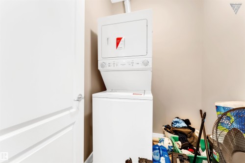 Laundry area featuring a stacked white washer and dryer unit - #418 392 Silver Berry Road Nw, Edmonton, AB - Indoor Photo Showing Laundry Room