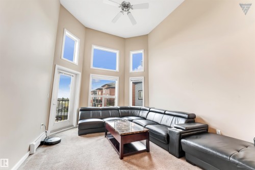 Living area featuring high ceilings, a ceiling fan, and large windows providing natural light - #418 392 Silver Berry Road Nw, Edmonton, AB - Indoor