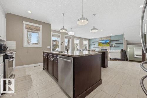 The kitchen features a spacious island with granite countertops and stainless steel appliances - 76 Newgate Way, St. Albert, AB - Indoor Photo Showing Kitchen With Upgraded Kitchen
