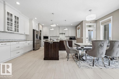 The open-concept kitchen and dining area features recessed lighting, pendant lights, and light-toned flooring - 76 Newgate Way, St. Albert, AB - Indoor