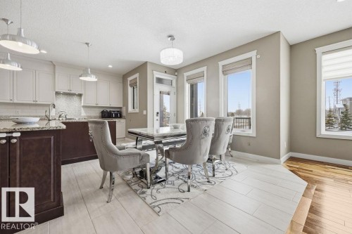 The property features an open concept kitchen and dining area with light-toned cabinetry, granite countertops, and stainless steel appliances - 76 Newgate Way, St. Albert, AB - Indoor Photo Showing Other Room