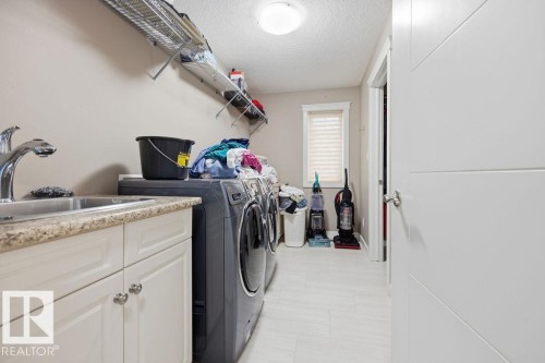 Dedicated laundry area featuring a utility sink, countertop, and storage cabinetry - 76 Newgate Way, St. Albert, AB - Indoor Photo Showing Laundry Room