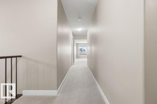 Inviting hallway featuring neutral-toned walls, plush carpeting, and a window providing natural light - 76 Newgate Way, St. Albert, AB - Indoor Photo Showing Other Room