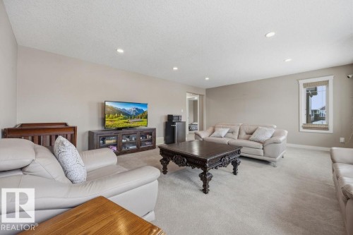 The spacious living area features recessed lighting, carpeted flooring, and a window with blinds - 76 Newgate Way, St. Albert, AB - Indoor Photo Showing Living Room