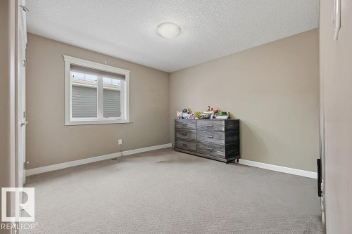 The room features neutral-toned walls, carpeted flooring, and a window providing natural light - 76 Newgate Way, St. Albert, AB - Indoor Photo Showing Bedroom
