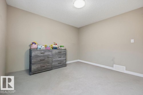 The room features neutral-toned walls, light-colored carpeting, and a ceiling light fixture - 76 Newgate Way, St. Albert, AB - Indoor