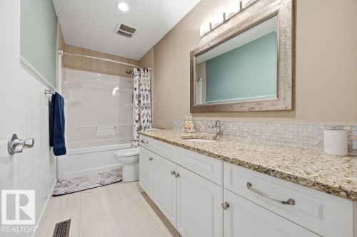 The bathroom features a spacious white vanity with a granite countertop, an undermount sink, and a large mirror with an ornate frame - 76 Newgate Way, St. Albert, AB - Indoor Photo Showing Bathroom