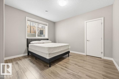 This room features light-toned walls, wood-look flooring, and a window with white trim - 76 Newgate Way, St. Albert, AB - Indoor Photo Showing Bedroom