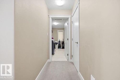 This hallway features light-colored walls, a carpeted floor, and a flush mount ceiling light - 76 Newgate Way, St. Albert, AB - Indoor Photo Showing Other Room