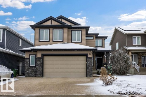 The property features a two-story exterior with light brown siding and dark trim accents - 76 Newgate Way, St. Albert, AB - Outdoor With Facade