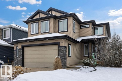 This property features a beige exterior with black trim, a two-car garage, and stone accents - 76 Newgate Way, St. Albert, AB - Outdoor
