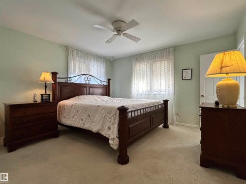 This room features light green walls and a ceiling fan - 13112 63 Avenue, Edmonton, AB - Indoor Photo Showing Bedroom