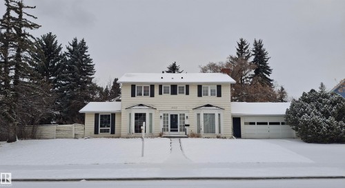 The property features a two-story design with a light-colored exterior and contrasting dark window shutters - 13112 63 Avenue, Edmonton, AB - Outdoor With Facade