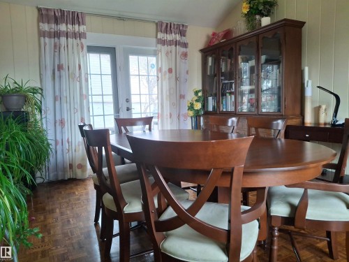Dining area featuring parquet wood flooring and light-colored paneled walls - 13112 63 Avenue, Edmonton, AB - Indoor Photo Showing Dining Room