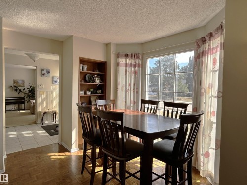 This dining area features hardwood flooring and an integrated wooden bookshelf - 13112 63 Avenue, Edmonton, AB - Indoor Photo Showing Dining Room