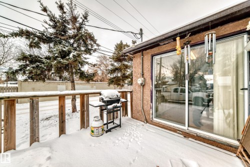 Snow covered deck with a grill and a fenced backyard - 15515 92A Avenue, Edmonton, AB - Outdoor With Exterior