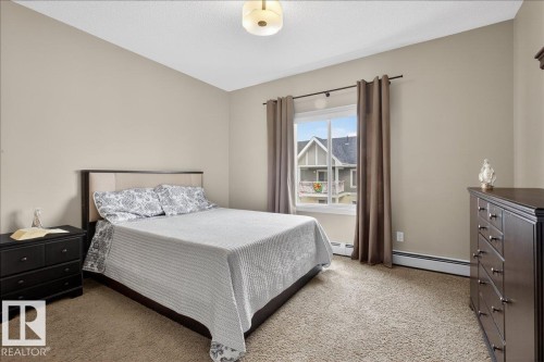 This bedroom features neutral-toned walls, a window with curtains, and carpeting - 413 2203 44 Avenue, Edmonton, AB - Indoor Photo Showing Bedroom