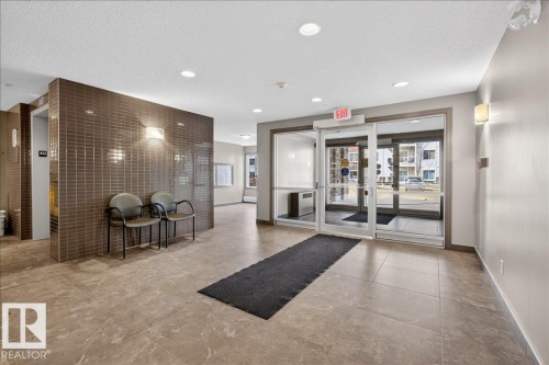 The property features a lobby with tiled flooring, recessed lighting, and a textured accent wall - 413 2203 44 Avenue, Edmonton, AB - Indoor Photo Showing Other Room