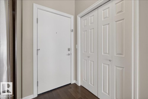 Entryway featuring dark hardwood flooring, a white paneled door, and bi-fold closet doors - 413 2203 44 Avenue, Edmonton, AB - Indoor Photo Showing Other Room