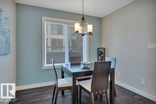Dining area featuring dark wood flooring, a window with blinds, and a chandelier light fixture - 9540 142 Street, Edmonton, AB - Indoor Photo Showing Dining Room